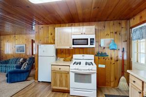 a kitchen with a white stove and a refrigerator at Chickadee Cabin in Saint Germain