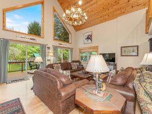 a living room with leather furniture and a chandelier at Island View I in Eagle River