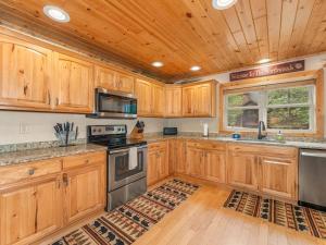 a kitchen with wooden cabinets and a wooden ceiling at Island View I in Eagle River