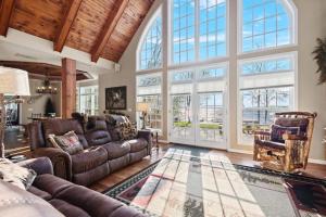 a living room with leather furniture and large windows at North Twin Lake House in Phelps