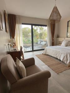 a bedroom with a bed and a couch and a chair at Villa YEMAYA - Villa d'hôtes in Ngaparou +79 photos