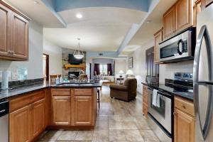 a kitchen with wooden cabinets and a living room at Chula Vista Condo, Unit 2344 in Wisconsin Dells