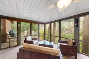a screened in porch with chairs and a table at Northwoods Resort in Woodruff