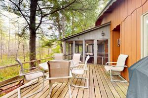 a deck with chairs and tables on a house at Northwoods Resort in Woodruff