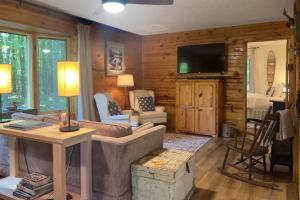 a living room with a couch and a tv at Northwoods Resort in Woodruff