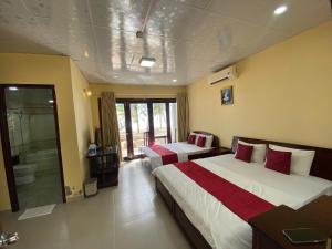 a hotel room with two beds and a bathroom at Beachfront Bungalow Cuu Long in Phú Quốc +13 photos