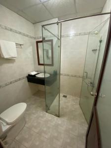 a bathroom with a toilet and a glass shower at Beachfront Bungalow Cuu Long in Phú Quốc