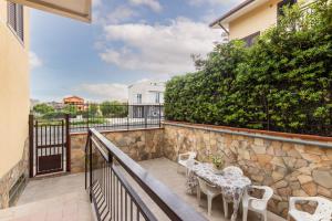 a balcony with a table and chairs and a stone wall at Casa Amica in Avola