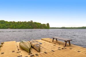 a dock with two boats and a bench on the water at Loon's Landing in Mercer