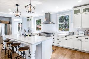 a kitchen with white cabinets and a large island with bar stools at Summer Breeze in Sayner +40 photos