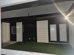 a garage with a green floor and white tiled walls at Alma House in Corpus Christi