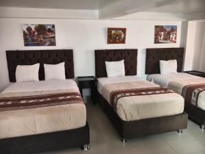 two beds in a room with two bedsitures at Hostal Ñustas INN in Machu Picchu