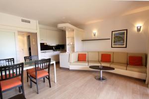 ein Wohnzimmer mit einem Sofa, einem Tisch und Stühlen in der Unterkunft Résidence Cala Sultana in Porto-Vecchio