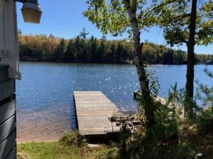a dock on a lake next to a house at Turtle Bay in Minocqua
