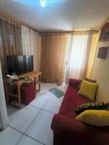 a living room with a couch and a television at Aconchego da Kika in Caruaru