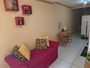a living room with a red couch and a table at Aconchego da Kika in Caruaru