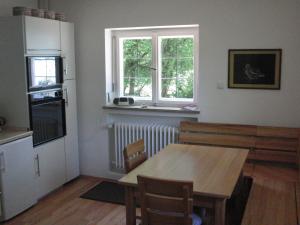 a kitchen with a wooden table and a window at Ferientraum Kobellstrasse in Rottach-Egern
