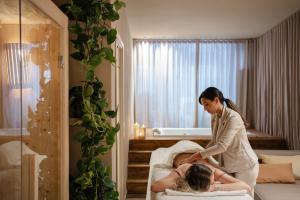 a woman is washing a woman on a bed at Palazzo Balsamo Boutique Hotel in Palermo