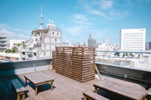 a balcony with benches and a view of a city at Nui. HOSTEL & BAR LOUNGE in Tokyo
