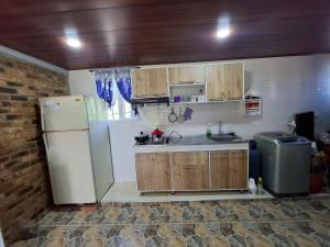 eine Küche mit weißem Kühlschrank und Holzschränken in der Unterkunft Suame in Sogamoso