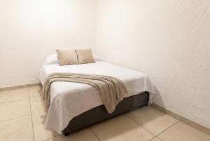 a bed with a blanket on top of it in a room at Casa en Providencia, 4 cuartos, Estacionamiento in Guadalajara