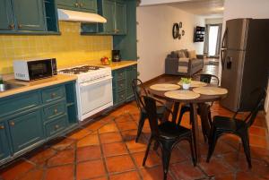 a kitchen with green cabinets and a table with chairs at Casa en Providencia, 4 cuartos, Estacionamiento in Guadalajara