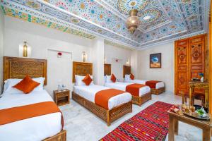 a hotel room with two beds and a coffered ceiling at Riad Nadalinn in Marrakesh