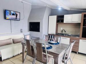 a dining room with a table and chairs and a couch at Casa de Fundos com 2 QuartosWi-fi e Estacionamento in Lages