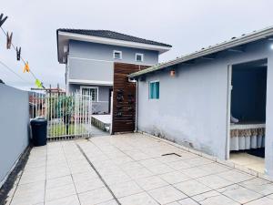 a house with a gate and a patio in front of it at Casa de Fundos com 2 QuartosWi-fi e Estacionamento in Lages