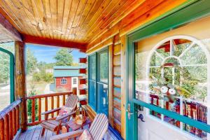 a porch with two chairs and a window at Blissful Deer Cabin in Friendship