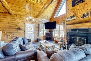 a living room with couches and a fireplace in a log cabin at Blissful Deer Cabin in Friendship