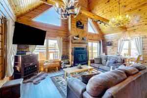 a living room with a couch and a television in a cabin at Blissful Deer Cabin in Friendship