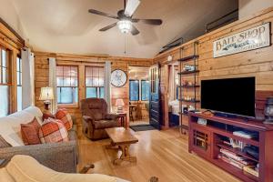 a living room with wooden walls and a flat screen tv at Little Red Lakeside Cabin in Three Lakes