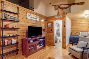 a living room with a flat screen tv in a cabin at Little Red Lakeside Cabin in Three Lakes