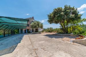 a walkway in front of a building with a tree at Apartments Villa Ana in Palit
