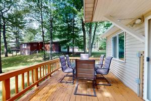a deck with chairs and a table on a house at Tall Pines in Woodruff