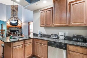 a kitchen with wooden cabinets and a sink at Chula Vista Condo 2145 & 2147 Full Property in Wisconsin Dells