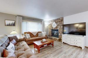 a living room with a couch and a tv at Knotty Pines in Wisconsin Dells