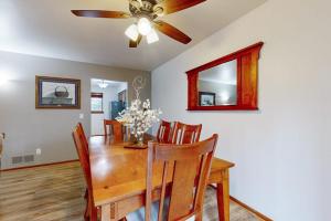 a dining room with a wooden table and a ceiling fan at Knotty Pines in Wisconsin Dells +17 photos