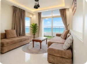 a living room with a couch and a table at Luxurious Beachfront Apartment in Alexandria