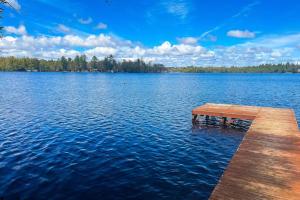 a dock in the middle of a large lake at Watermelon Retreat & Suite in Three Lakes