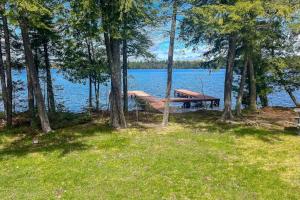 a picnic table sitting next to a lake with trees at Watermelon Retreat & Suite in Three Lakes