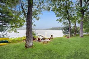 a park with a picnic table and a bench by the water at Hooked on Johnson in Arbor Vitae