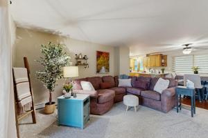 a living room with a brown couch and a kitchen at Hooked on Johnson in Arbor Vitae