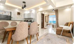 a kitchen and living room with a table and chairs at Luxurious Beachfront Apartment in Alexandria