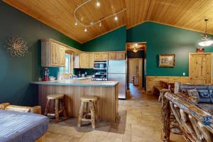 a kitchen and living room with green walls and wooden cabinets at The Aspen in Mercer +14 photos