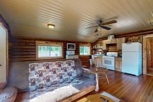 a living room with a couch and a kitchen at The Hunters Den in Mercer