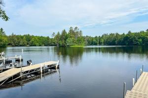a dock on a lake with trees in the background at Pine Tree House in Mercer