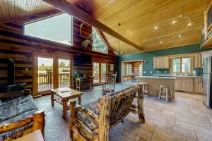 a large living room with wooden ceilings and a kitchen at Pine Tree House in Mercer