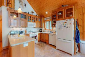 a kitchen with wooden cabinets and a white refrigerator at Shangri La in Eagle River